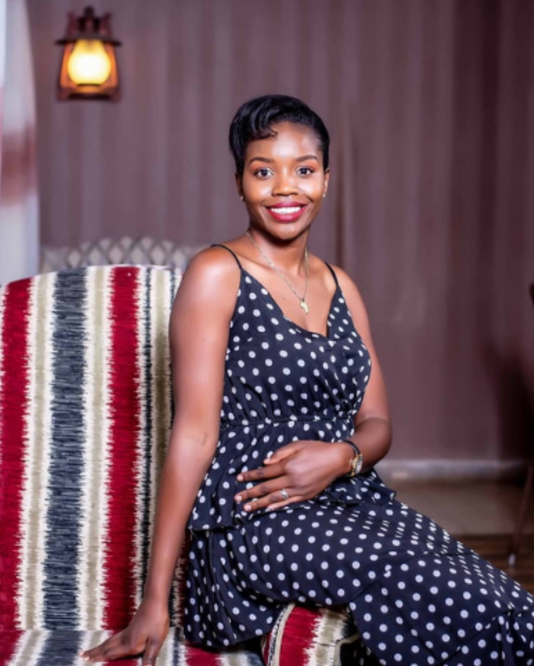 Tina, founder of Yaara Design Studio, seated on a patterned armchair in a warmly lit interior